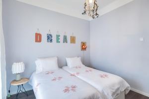 a bedroom with a bed with white sheets and a chandelier at Endemic - Concept Apartment in Funchal