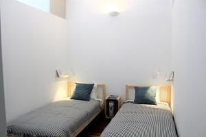 ポルトにあるBonjardim Flats - T1 com varandaの白い壁の客室で、ツインベッド2台が備わります。