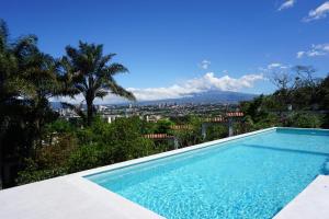 a swimming pool with a view of a city at Posada el Quijote in San José