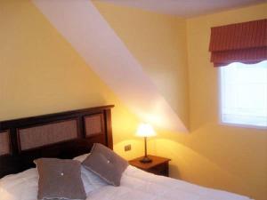 Schlafzimmer mit einem Bett mit weißer Bettwäsche und einem Fenster in der Unterkunft Apart Hotel en Puerto Montt in Puerto Montt