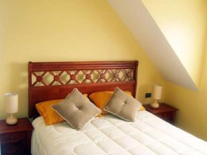 a bedroom with a bed with two pillows on it at Apart Hotel Croacia in Puerto Montt