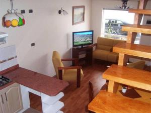 a living room with a table and a couch and a television at Apart Hotel en Puerto Montt in Puerto Montt