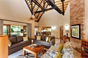 a living room with couches and a brick wall at Kruger Park Lodge Unit No 252 with private pool in Hazyview