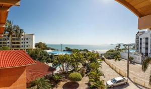 a view of a resort with a car and the beach at Pousada Residencial Alamandas in Florianópolis