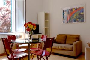 a dining room with a table and chairs and a couch at Ilsoleresort in Genoa