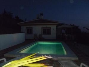 - une piscine en face d'une maison la nuit dans l'établissement Villa Competa, à Cómpeta