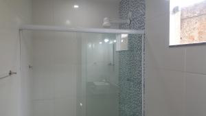 a bathroom with a shower with a glass door at Pousada Viva Mar in Saquarema