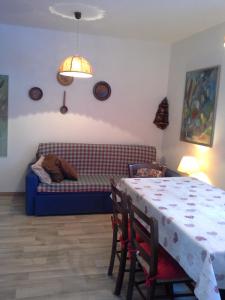 a living room with a table and a couch at Appartamento Niki Campitello in Campitello di Fassa