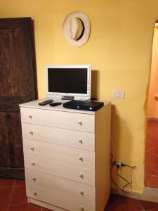 a computer monitor sitting on top of a dresser at Appartamento del cuore in Pitigliano