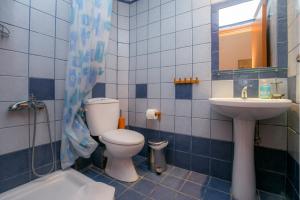 a blue tiled bathroom with a toilet and a sink at Antheon Villas in Chrysi Ammoudia +29 photos