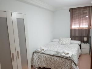 マドリードにあるPradera San Isidro 1の白いベッドルーム(ベッド1台、窓付)