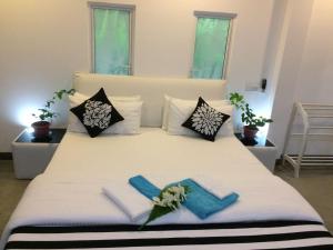 a bedroom with a large white bed with pillows at Villa The Leaf in Weligama