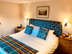 a bedroom with a large bed with blue pillows at The Dorset Arms Pub & Cottage Rooms in Groombridge