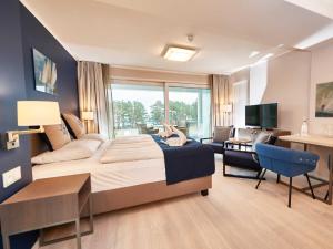 een hotelkamer met een groot bed en een bureau bij Strandresort Prora - WG 216 mit Meerblick und IR-Sauna in Binz