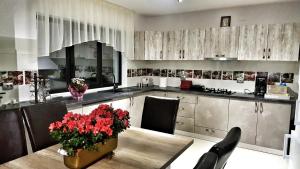 una cocina con una mesa con flores rojas. en Casa Arini Bellevue, en Vatra Dornei