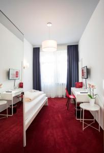 a hotel room with two beds and a red carpet at Hotel Mille Stelle City in Heidelberg