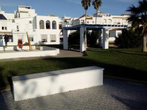 コニル・デ・ラ・フロンテーラにあるPiso Playa Los Bateles Conilの白い建物の前を歩く者