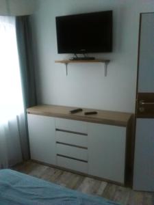 a bedroom with a desk with a television on a wall at Domek przy lesie in Gdańsk