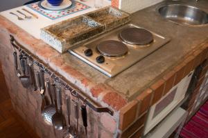 a kitchen counter with a stove and a sink at Casa Temporada Itaipava in Petrópolis