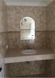 un baño con lavabo y espejo en La Casita de Thor, en Monte Hermoso