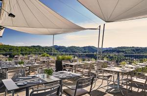 a restaurant with tables and chairs and an umbrella at LOISIUM Wine & Spa Hotel Südsteiermark in Ehrenhausen