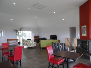 una sala da pranzo con tavoli, sedie e un divano di Swan Lake Guest House a Ventnor
