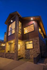 una casa grande con fachada de piedra por la noche en Hotel Carpa Manzano, en Punta Arenas