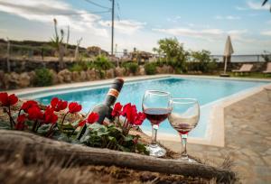 キサモスにあるPericles Beach Villaのスイミングプールの隣に座るワイン2杯