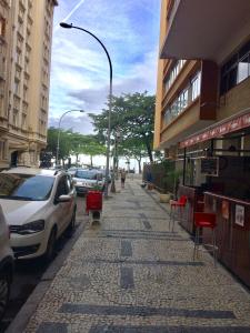 une rue avec des voitures garées sur le côté de la route dans l'établissement Studio Copacabana, à Rio de Janeiro