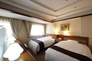 A bed or beds in a room at Hotel Hiroshima Garden Palace