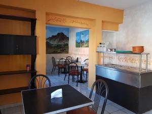 a restaurant with a table and chairs and a counter at Hotel Colonial San Jorge in Monclova