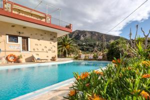 a swimming pool in front of a house with a mountain at Pericles Beach Villa in Kissamos