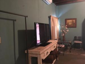 uma sala de estar com uma televisão numa mesa de madeira em Hostal Doña Carlota Hotel em Cuatrociénegas de Carranza