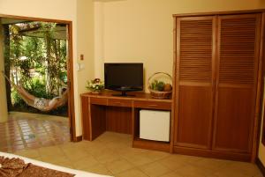 a room with a television on a wooden desk at Palm Garden Resort in Rawai Beach
