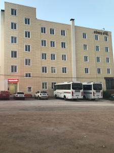 dwa autobusy zaparkowane na parkingu przed budynkiem w obiekcie Gunes Hotel w mieście Hacıbektaş