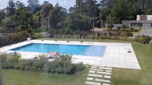 a woman laying in a swimming pool in a yard at Bellagio Tower in Punta del Este