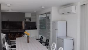 a kitchen with a table with chairs and a refrigerator at Bellagio Tower in Punta del Este