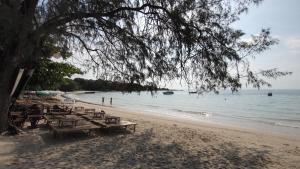 eine Gruppe Picknicktische am Strand in der Unterkunft Crescent Bay Resort in Ko Samed