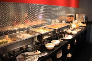 a buffet line with dishes of food in a restaurant at B my Hotel in Tijuana