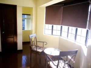 una stanza con due sedie, un tavolo e una finestra di The Ambassador Hotel a Tacloban