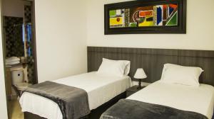 a bedroom with two beds and a picture on the wall at Hotel Viña Del Mar in Santa Marta +17 photos