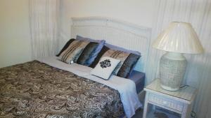 a bed with pillows and a lamp on a table at 1002 Crystal Court Condominiums in Saint James +9 photos