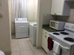 a small kitchen with a stove and a microwave at 1002 Crystal Court Condominiums in Saint James