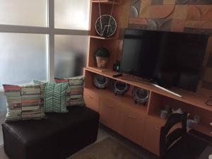 Sky's at Prime Residences -Tagaytay في تاجيتاي: غرفة معيشة مع تلفزيون بشاشة مسطحة وأريكة