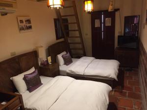 a bedroom with two beds and a ladder at No. 86 Homestay of Shuitou in Jincheng