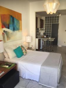 1 dormitorio con 1 cama blanca grande y cocina en Copacabana: lounge lindo, confortável e com vista do mar, en Río de Janeiro
