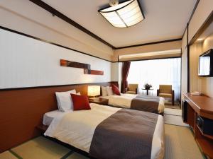a hotel room with two beds and a television at Heian No Mori Kyoto in Kyoto
