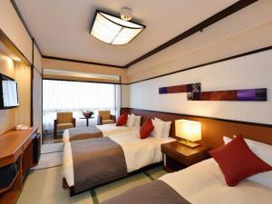 um quarto de hotel com duas camas e uma televisão em Heian No Mori Kyoto em Quioto
