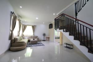 本哲的住宿－Diyar Villas Puncak K3/2A，一间带楼梯和沙发的客厅