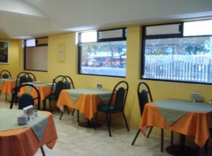 a dining room with tables and chairs and a screen at Hotel Terminal de Puebla in Puebla
